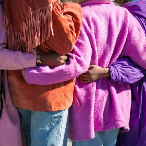 back of four women dressed in bright lilac, pink and orange coats as if celebrating International Women's Day with HIP